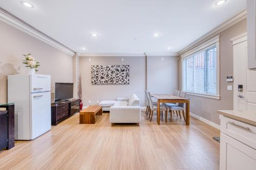 a kitchen and dining room with a table and a kitchen and a living room at Cozy two beds lower level suite in Vancouver West in Vancouver