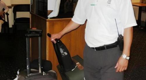 a man in a white shirt with a suitcase at Hotel Harrington in Washington