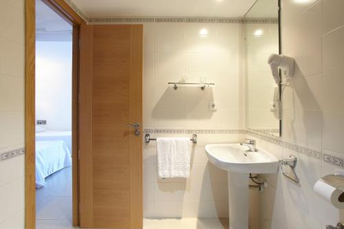 a bathroom with a sink and a mirror at Aparthotel Nereida in San Antonio Bay