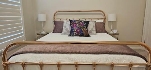 1 cama con marco de metal y almohada en Balnagowan, en Moss Vale