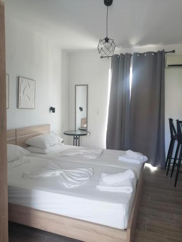 a bedroom with a large bed with white sheets at Kefalos Studios Stamatia in Kefalos