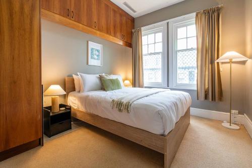 una camera da letto con un letto grande e una finestra di Dolly's Cottage - Timeless Retreat near Hobart CBD a Hobart