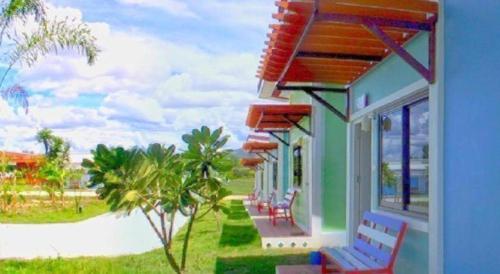 a house with a row of chairs on the porch at BanRai ChernMa Resort in Tak