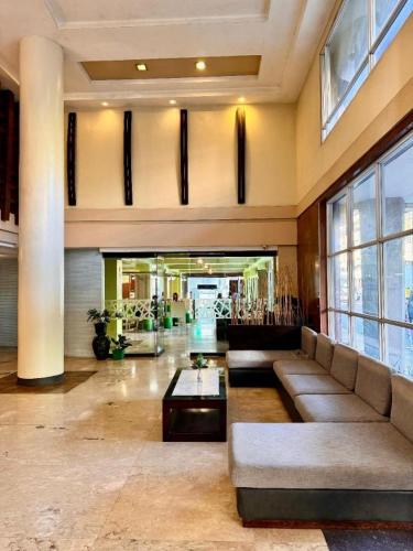 a lobby with a couch and a table in a building at MO2 Westown Hotel San Juan in Bacolod