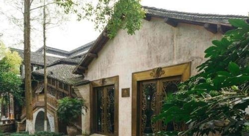 a house with a gate and a building at Eden Club House in Tongxiang