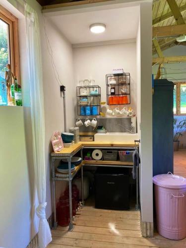 a kitchen with a table and a counter with food at The Cabin at Tedburrow rural retreat perfect for couples in Culmstock