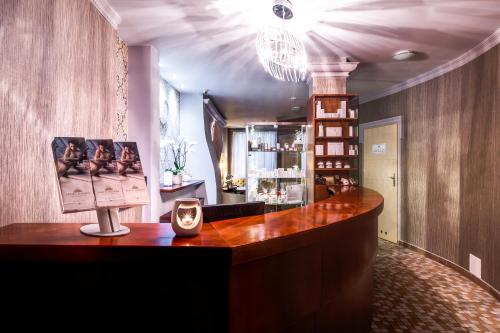 a lobby with a desk with a clock on it at Hotel Aurora Family & SPA in Międzyzdroje