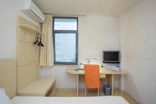 a small room with a desk and a bed and a table at Magnotel Shanghai Henglong Plaza in Shanghai