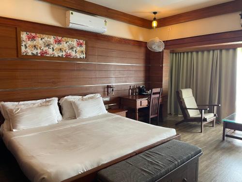 a bedroom with a bed and a desk and a table at Vayas Holistic Wellness Resort in Attappādi