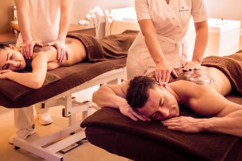 a man laying on a bed in a massage salon at Hotel Aurora Family & SPA in Międzyzdroje
