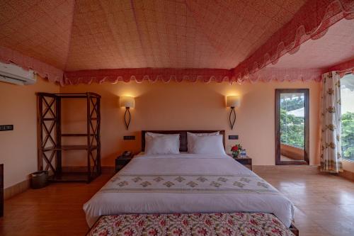 a bedroom with a large bed and a window at Ratan Villas Sariska in Alwar