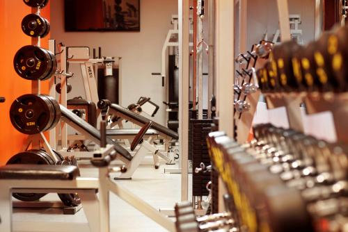 a gym with rows of equipment in a room at Hotel Aurora Family & SPA in Międzyzdroje