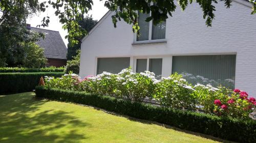 a house with a garden of flowers in front of it at B&B prince d’Orange Waterloo in Waterloo