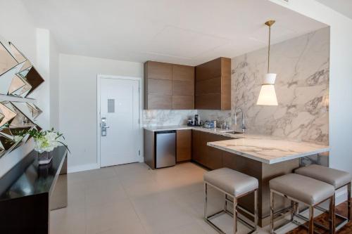 a kitchen with a large island with stools in it at Omni Frisco at The Star in Frisco