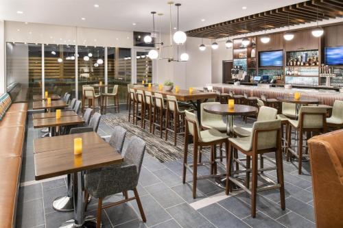 a restaurant with tables and chairs and a bar at Hyatt Place East Moline/Quad Cities in East Moline