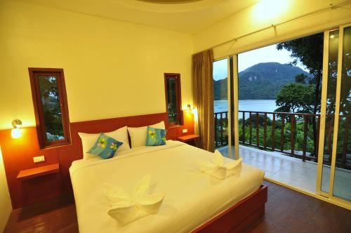 a bedroom with a bed with a large window at Sea View Bungalow in Phi Phi Don