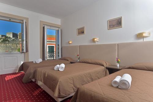 Cette chambre comprend 3 lits avec des serviettes blanches. dans l'établissement Konstantinoupolis, à Corfou