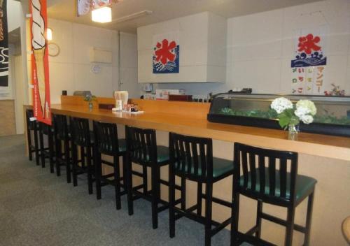 a bar with a row of chairs in a waiting room at Hidamarinoyu mix dormitory / Vacation STAY 40392 in Takayama