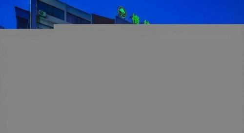 a white banner with green signs on top of a building at GreenTree Inn Yancheng Yandu District Hongxing Macalline Century Avenue in Yancheng