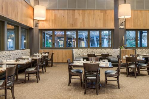 a dining room with tables and chairs and windows at Omni Hilton Head Oceanfront Resort in Hilton Head Island