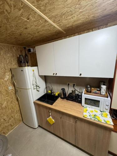 a kitchen with white cabinets and a white refrigerator at Dream House in Yerevan