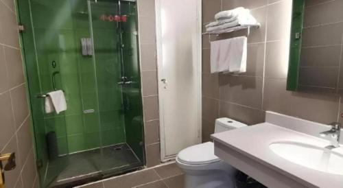 a bathroom with a shower and a toilet and a sink at GreenTree Inn Xi'an Terracotta Warriors Huaqing Pool Metro Station in Xi'an