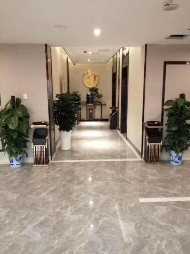 a hallway with potted plants in a building at Kyriad Marvelous Hotel Xiangyin Bus Station in Xiangyin