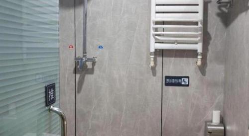 a metal door in a room with a sign on it at 7 Days Inn Harbin Medical University First Affiliated Hospital in Harbin