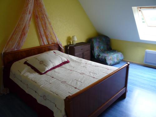 a bedroom with a large bed and a chair at Briois Cristelle in Penmarcʼh