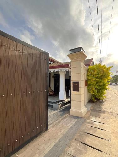 a building with a white column next to a building at Villa Sea Wave in Hikkaduwa