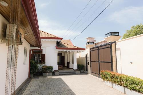 a white house with a gate and a driveway at Villa Sea Wave in Hikkaduwa