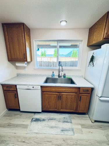 a kitchen with a sink and a white refrigerator at Fishermens paradise in Forks