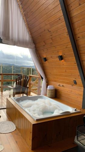 a hot tub on a deck with a wooden ceiling at Chales alto do morro 1, conforto e vista privilegiada in Rancho Queimado