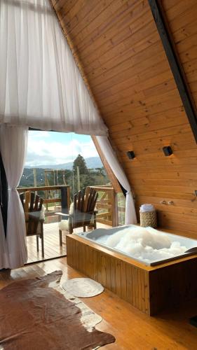 a hot tub in a room with a wooden ceiling at Chales alto do morro 1, conforto e vista privilegiada in Rancho Queimado