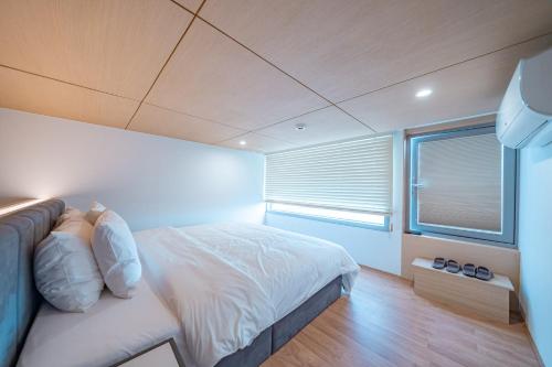 a bedroom with a large bed and a window at Ocean Bliss in Ulsan