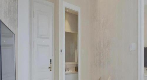 a bathroom with a white door and a mirror at Changshu Please Hotel in Changshu