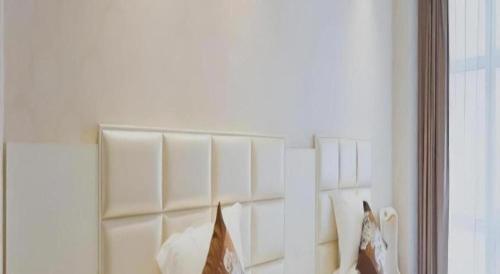a mirror on a wall in a room with pillows at Changshu Please Hotel in Changshu