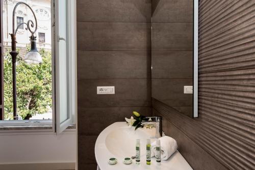 ein Badezimmer mit einem weißen Waschbecken und einem Spiegel in der Unterkunft Navona Luxury Guesthouse in Rom