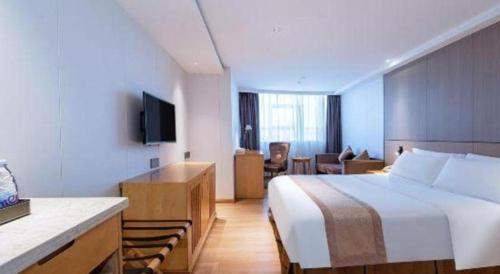 a hotel room with a bed and a television at Zhongshan Louis Hotel in Zhongshan