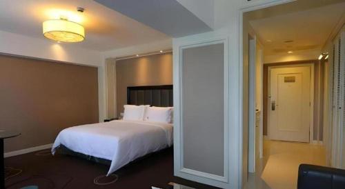 a bedroom with a large white bed in a room at Jinjiang Metropolo Hotel Classiq YMCA People Square in Shanghai