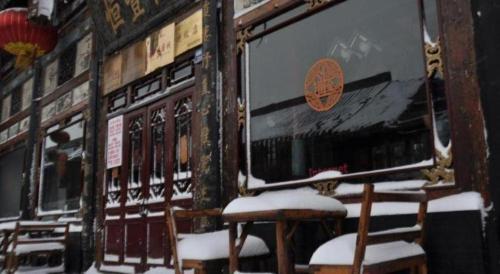 a row of chairs in the snow next to a train at Pingyao Yufengheng Hotel in Pingyao