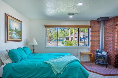 een slaapkamer met een blauw bed en een bakstenen muur bij Cozy Cabin by Bass Lake, with Boat Slip in Bass Lake