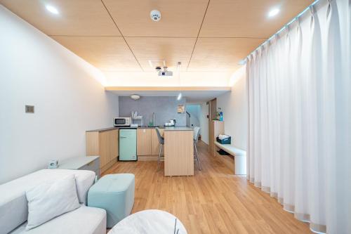 a living room with a couch and a kitchen at Ocean Bliss in Ulsan