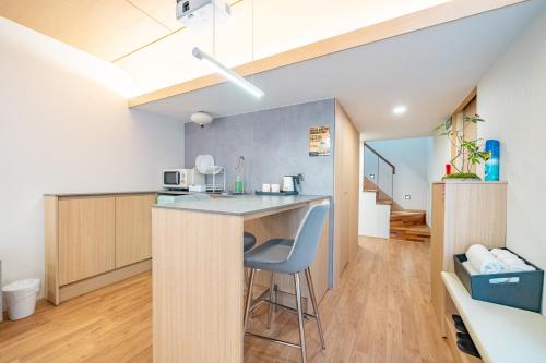 a kitchen with a counter with a blue chair at Ocean Bliss in Ulsan