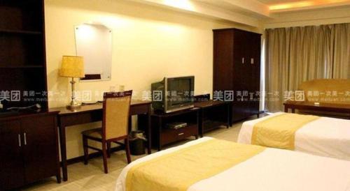 a hotel room with two beds and a desk with a computer at Yitel Collection Lianyungang High-speed Railway Station Suning Plaza in Lianyungang