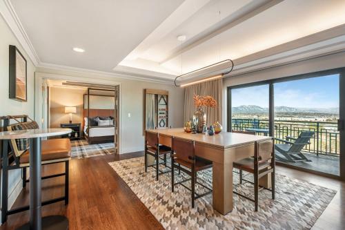 a dining room with a table and a bedroom at Omni Interlocken Hotel in Broomfield