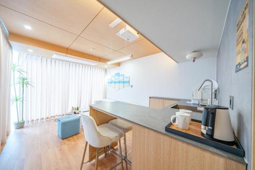 a kitchen with a counter and chairs in a room at Ocean Bliss in Ulsan