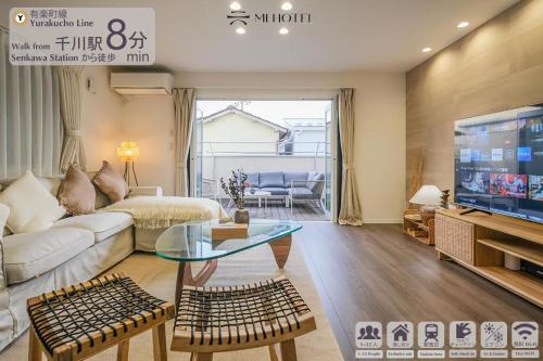 a living room with a couch and a tv at UN-Villa in Tokyo