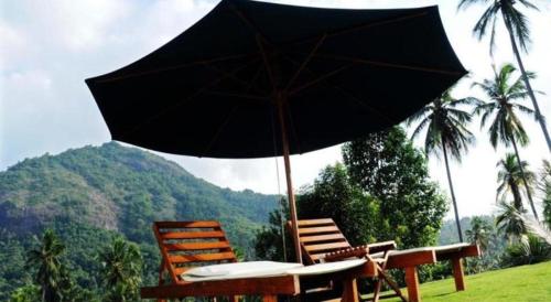 a table and two chairs with an umbrella at Brook Boutique in Sigiriya