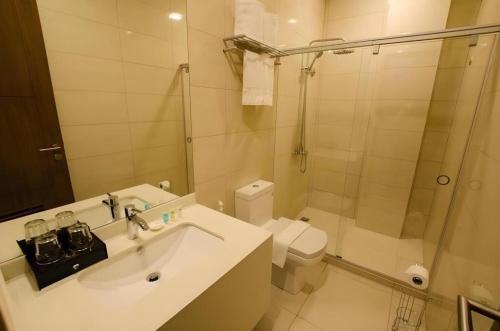 a bathroom with a sink and a toilet and a shower at Oryza Hotel in Santiago City